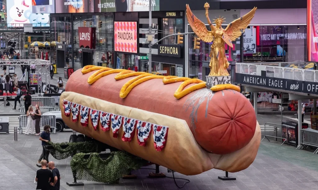 Artists’ monumental hot dog sculpture, now with patriotic toppings, returns to Times Square